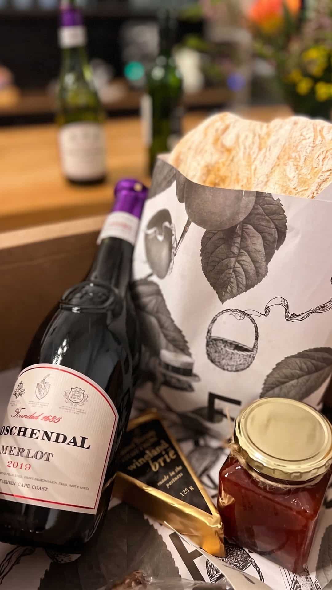 Picnic with a bottle of Boschendal Merlot, cheese, and jam at a wine farm in the Cape Winelands near Cape Town